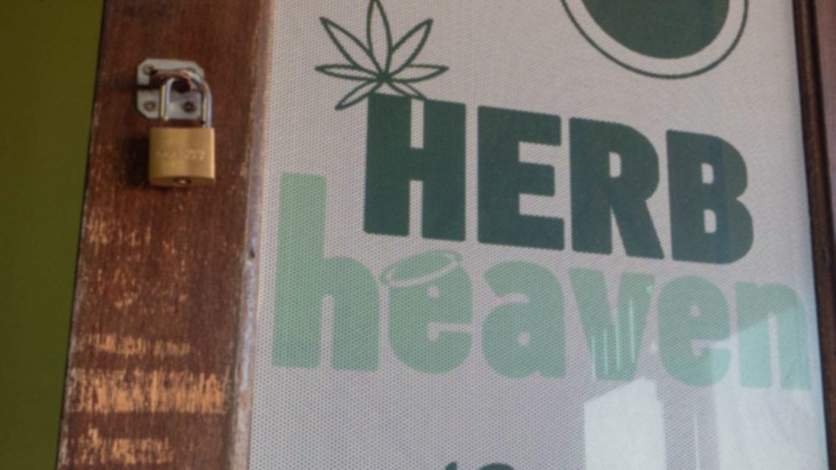The frosted Herb Heaven Social Club window at the door